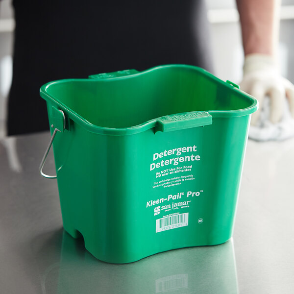 A person using a San Jamar Green Cleaning Kleen-Pail Pro bucket.