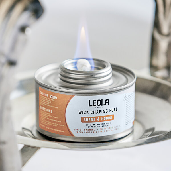 A Leola Fuel can with a flame burning on a table.