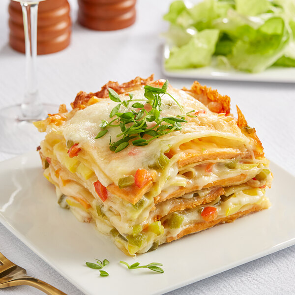 A plate of Barilla gluten-free lasagna with vegetables on a table.