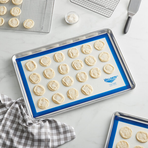 A tray of cookies on a Vollrath blue silicone baking mat.