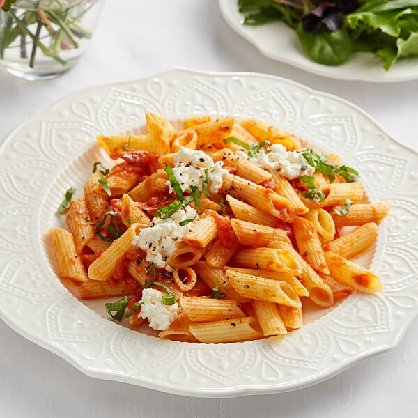 A plate of Barilla gluten-free penne pasta with sauce and cheese.