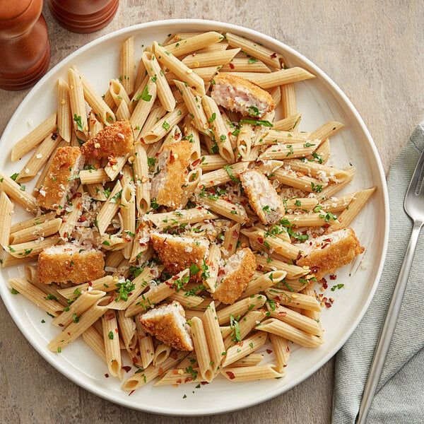 A plate of Barilla whole grain penne pasta with chicken and parmesan cheese.