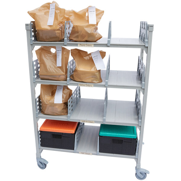 A Cambro Camshelving Premium Series Flex Station with 4 shelves holding bags and boxes.
