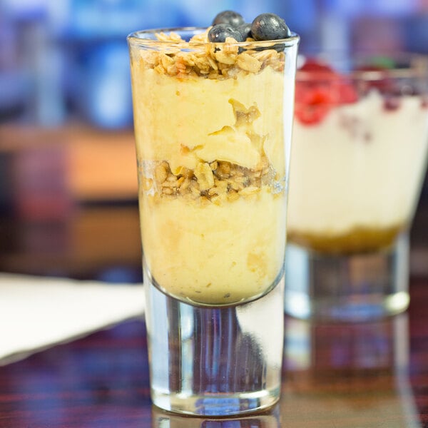 A Libbey Troyano shooter glass filled with dessert with blueberries and granola.