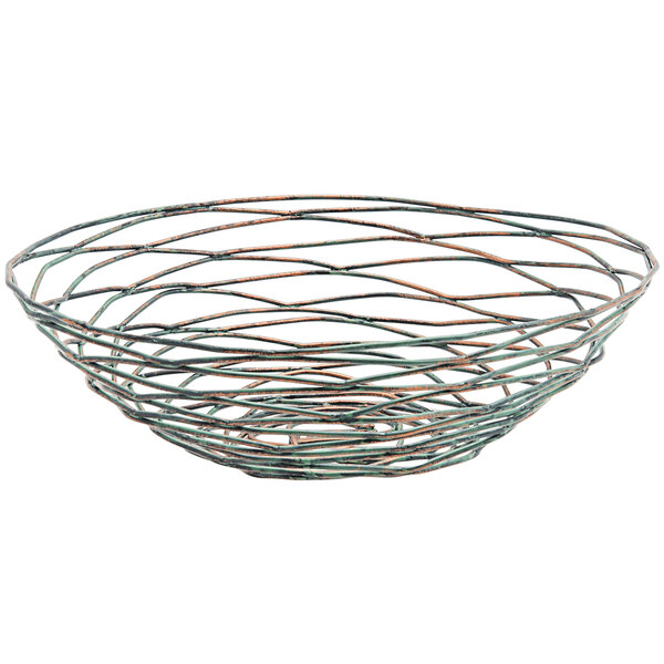 A Front of the House Patina hand-painted fused iron round basket with orange and green spiral designs.