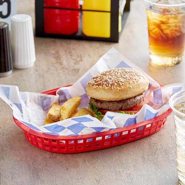 A white basket lined with blue check paper holding a burger and fries.