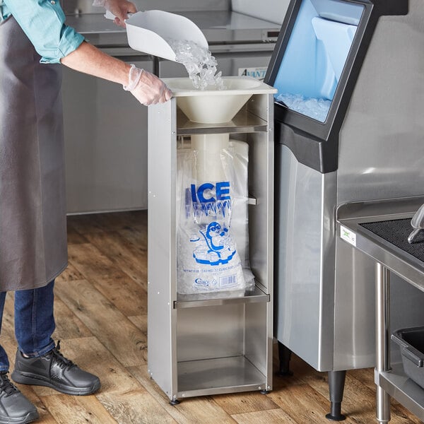 A man wearing a brown coat using a Choice Ice Bagger to bag ice from a white bowl.