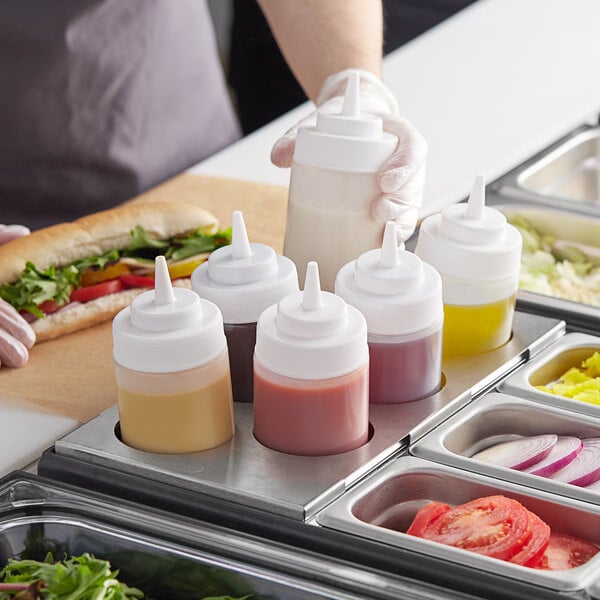 A tray of food with condiments in white squeeze bottles.