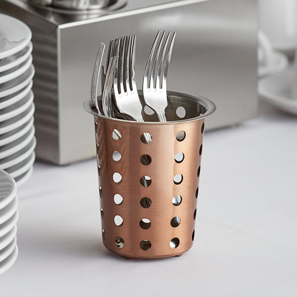 A Choice copper flatware holder filled with silverware on a table.