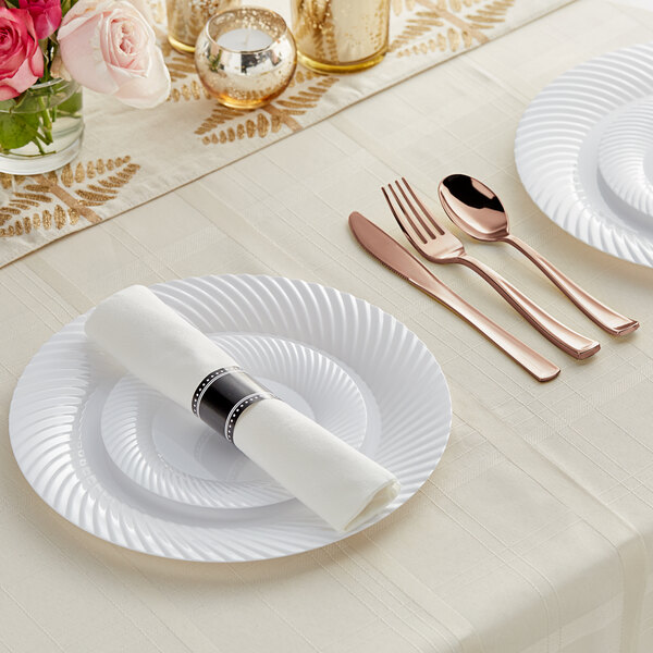 A white table setting with white Visions plates, Classic Rolled flatware, and a napkin.