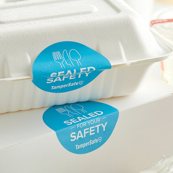 A white food container with blue TamperSafe labels on top of it.