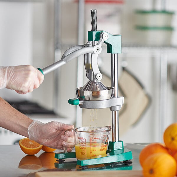 A person using a Garde XL Manual Citrus Juicer to make orange juice.