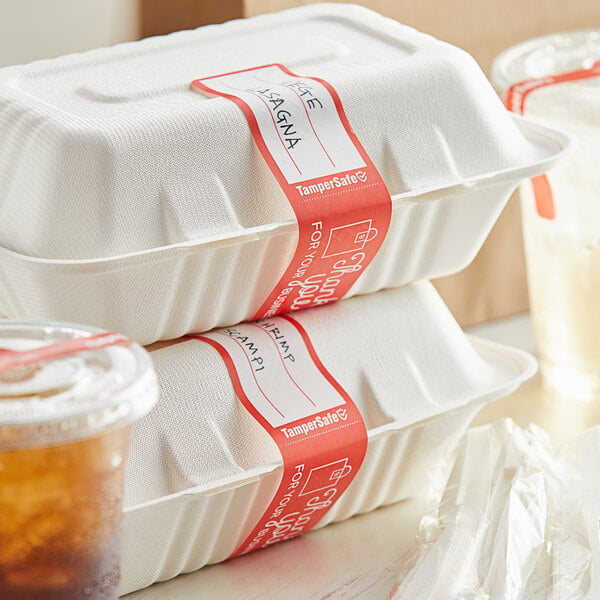 A white styrofoam takeout container with a red TamperSafe label on it.
