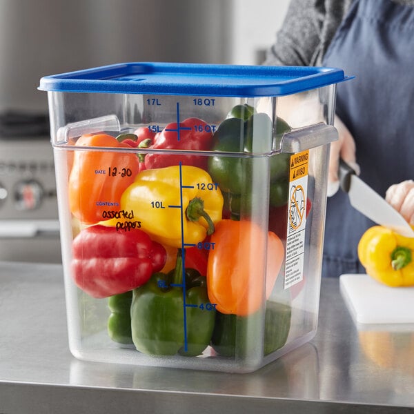 A woman cutting yellow and red bell peppers in a Vigor food storage container on a kitchen counter.