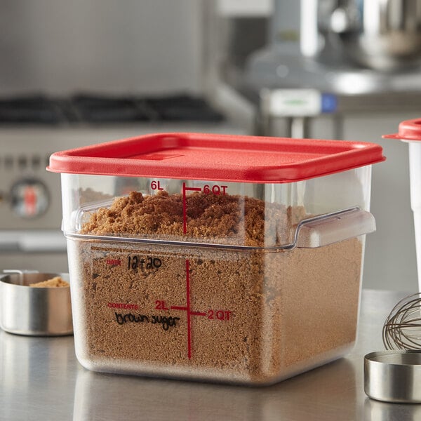 A close-up of a Vigor clear polycarbonate food storage container filled with brown sugar.