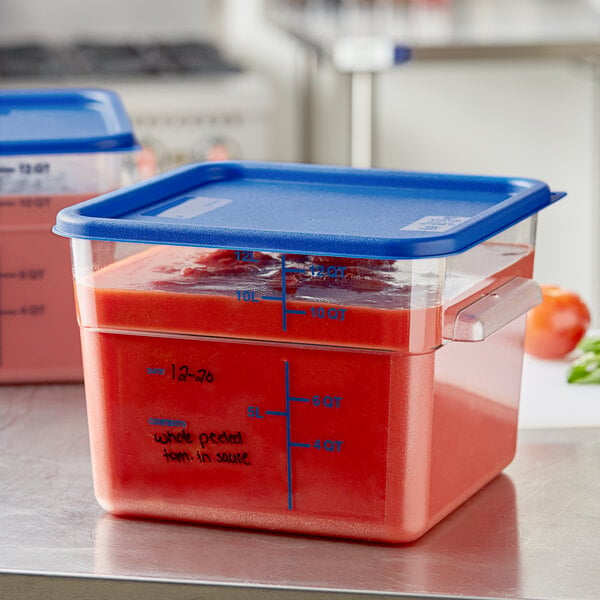 Two Vigor clear square food storage containers with blue lids on a counter.