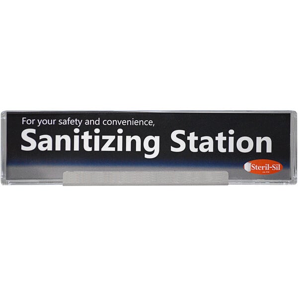 A Steril-Sil two-sided sign with white text that says "sanitizing station" on a counter.