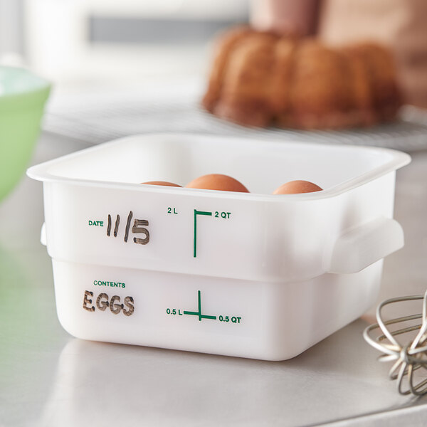 A white Carlisle food storage container with eggs in it.