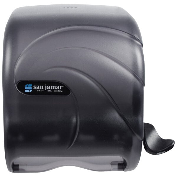 A black San Jamar roll towel dispenser with a black and white sign.