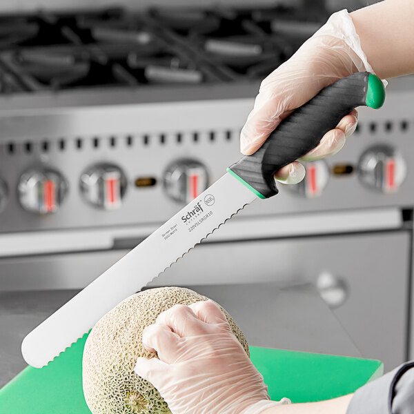 A hand in a glove holding a Schraf serrated slicing knife over a melon.