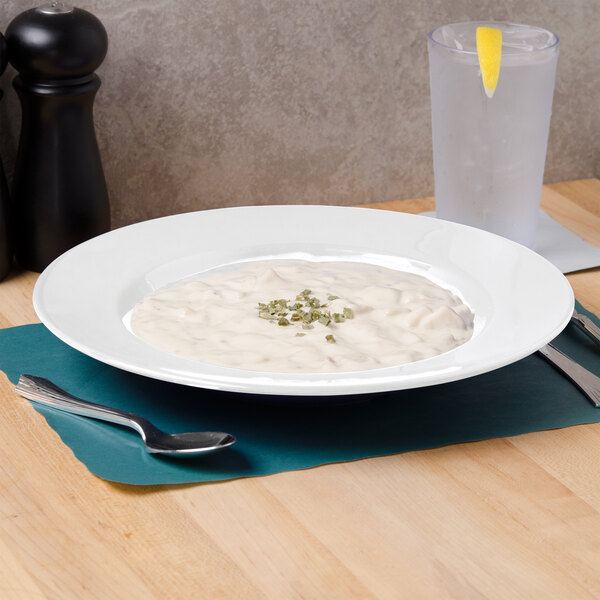 A white Thunder Group melamine pasta bowl filled with soup on a table.