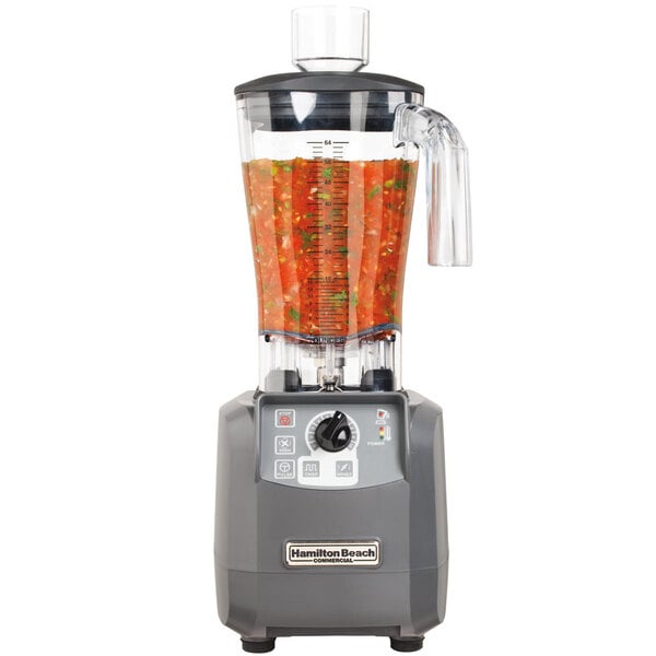 A Hamilton Beach food blender with a clear container blending fruit and vegetables.