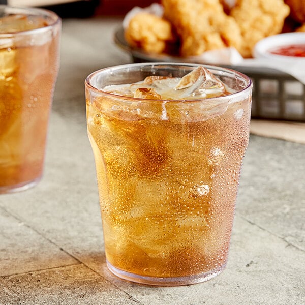 Two Choice clear plastic paneled tumblers filled with iced tea on a table with a basket of chicken