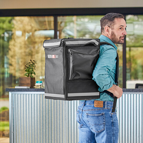 A man carrying a ServIt Slim backpack delivery bag.