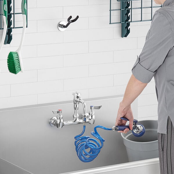 A person using a Waterloo Pet Grooming Faucet hose to wash a sink.