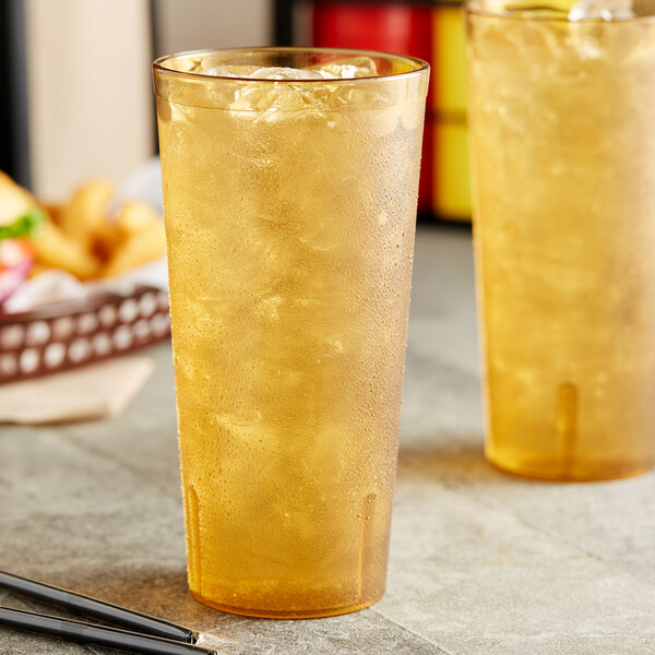 A pair of Choice amber plastic tumblers with ice and liquid.