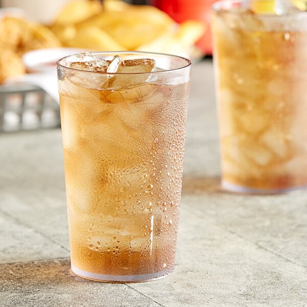 Two Choice clear plastic pebbled tumblers filled with ice tea on a table.