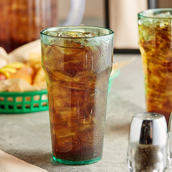 A green Choice plastic tumbler filled with iced tea and ice.