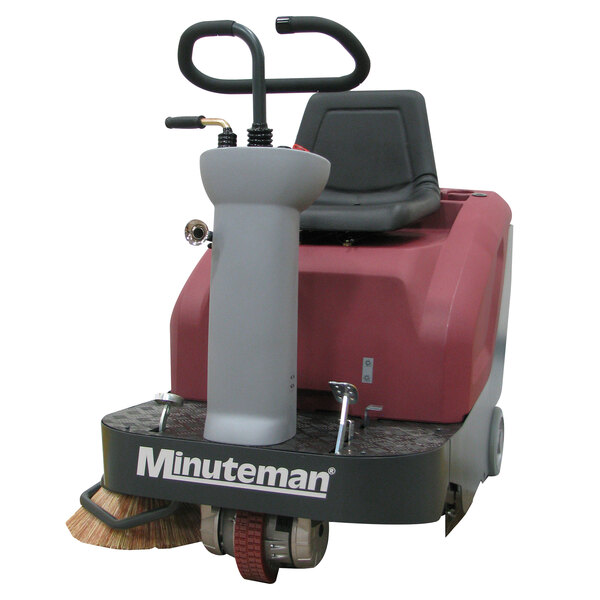 A red and white Minuteman Kleen Sweep floor sweeper with a handle and pole.