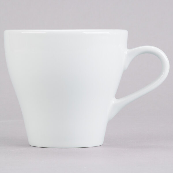 A close-up of the handle of a Tuxton Europa white cappuccino mug.
