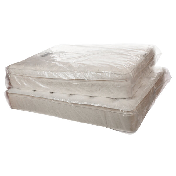 A stack of mattresses in a Lavex extra large queen sized mattress bag on a roll.