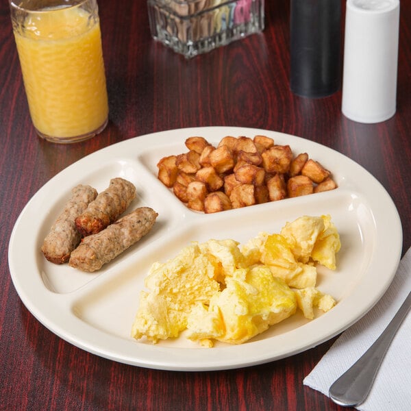 A Carlisle tan melamine 3-compartment plate with breakfast food on a table.