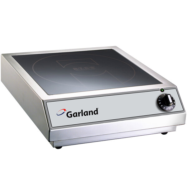 A Garland countertop induction range on a counter in a professional kitchen.