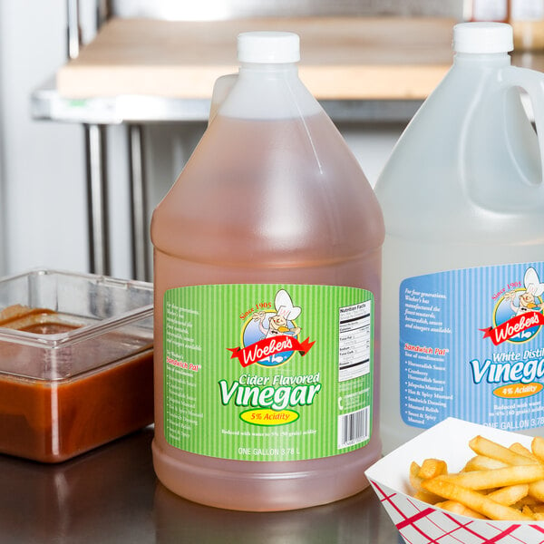 A jug of Woeber's cider flavored vinegar next to a group of French fries.