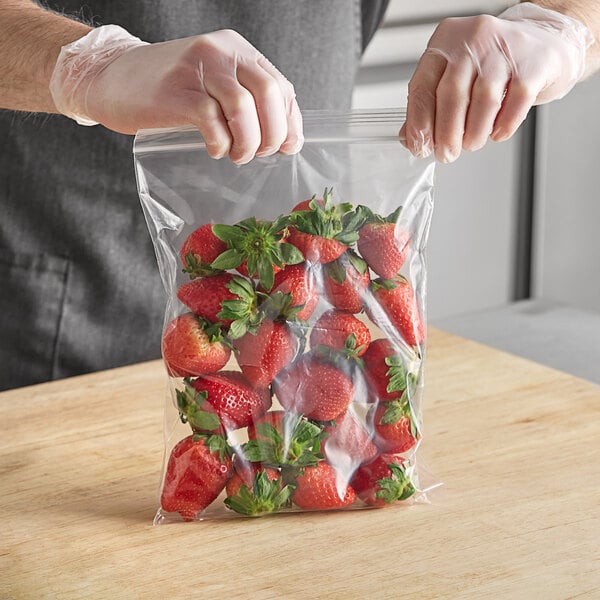 A person in gloves holding a Choice plastic bag of strawberries.