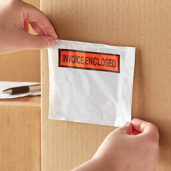 A hand holding a box of Lavex printed polyethylene invoice packing list envelopes.