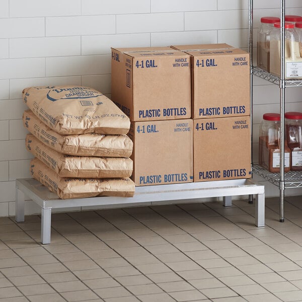 A Regency aluminum dunnage rack holding cardboard boxes and brown packages.