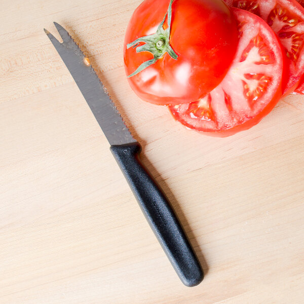 A Victorinox tomato knife next to tomato slices.