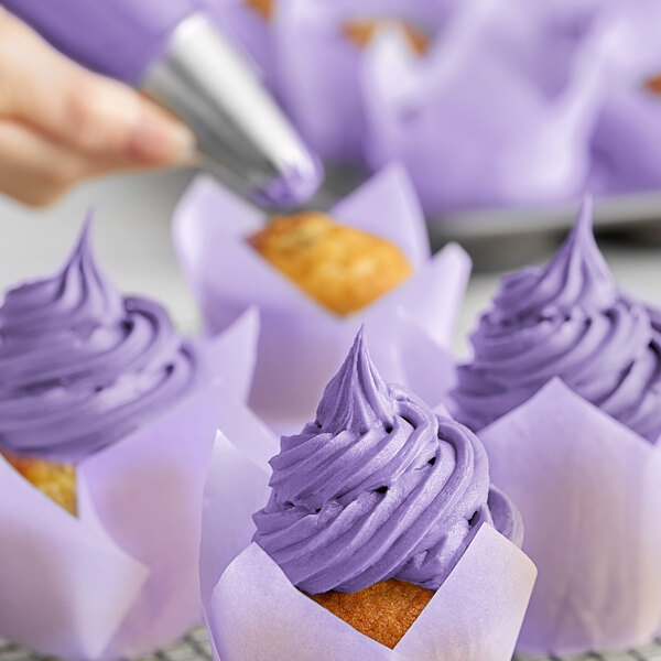A close-up of a cupcake with purple Chefmaster frosting swirl.
