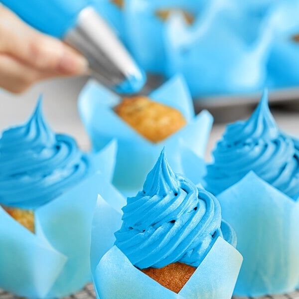 A close up of a cupcake with blue swirls on top using Chefmaster Neon Brite Blue Liqua-Gel Food Coloring.