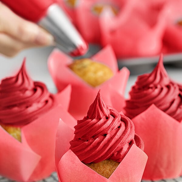 A close-up of a Chefmaster red frosted cupcake.