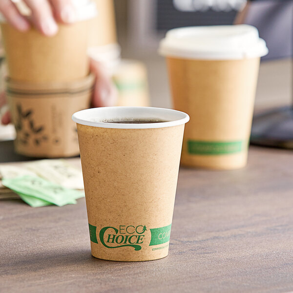 A hand holding a brown EcoChoice paper cup with a white lid.