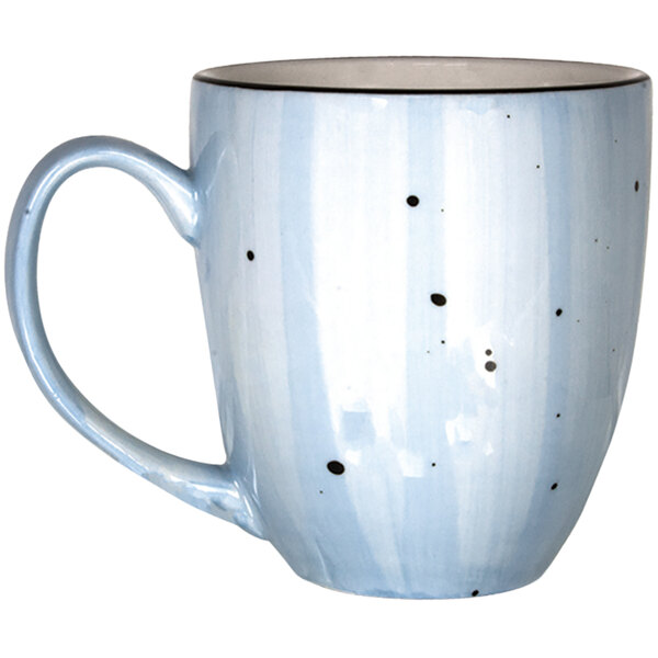 A close-up of the handle of a blue and white International Tableware Rotana coffee mug with black dots.