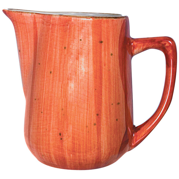 A red International Tableware porcelain creamer with a handle.