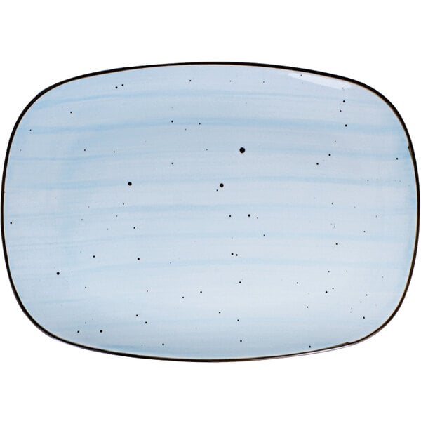 A white porcelain rectangular platter with blue and black dots on it.