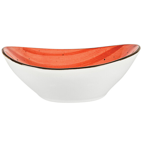 An International Tableware oval porcelain bowl with a white base and red rim.